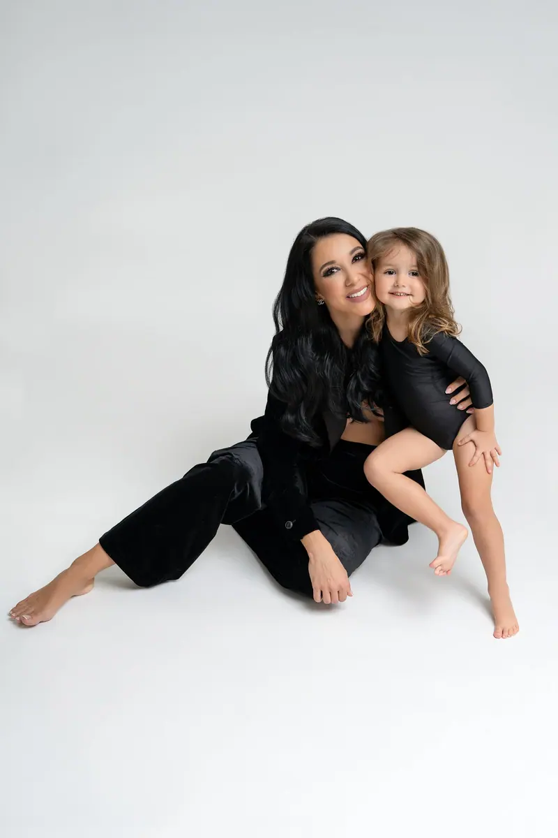 Fotenie mama a baby — mama a dcérka v čiernom, sediace na zemi