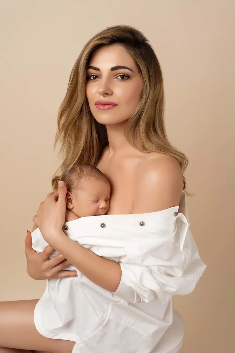 Fotenie mama a baby — mama v bielej košeli s novorodencom na hrudi
