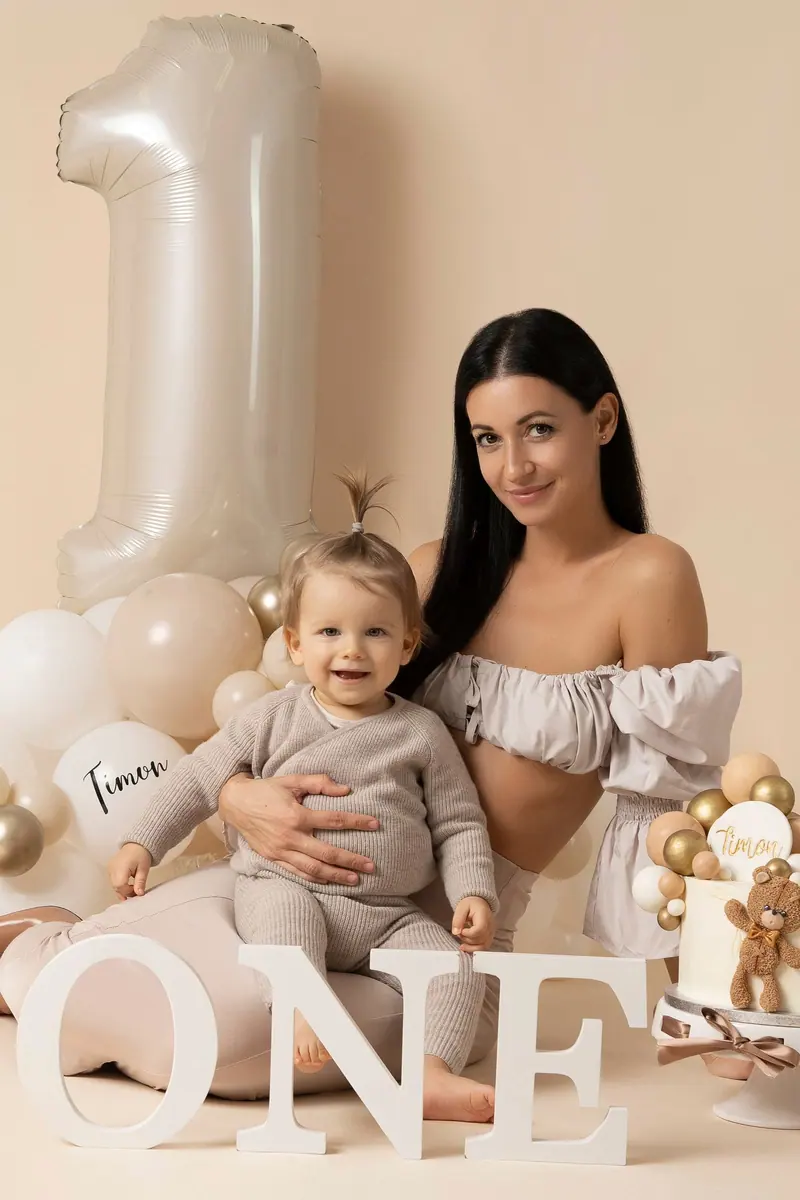 Narodeninové fotenie — mama sedí s ročným dieťaťom, „ONE“ a torta