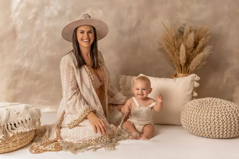 Fotenie mama a baby — mama v klobúku s bábätkom v boho scéne so sušenou trávou