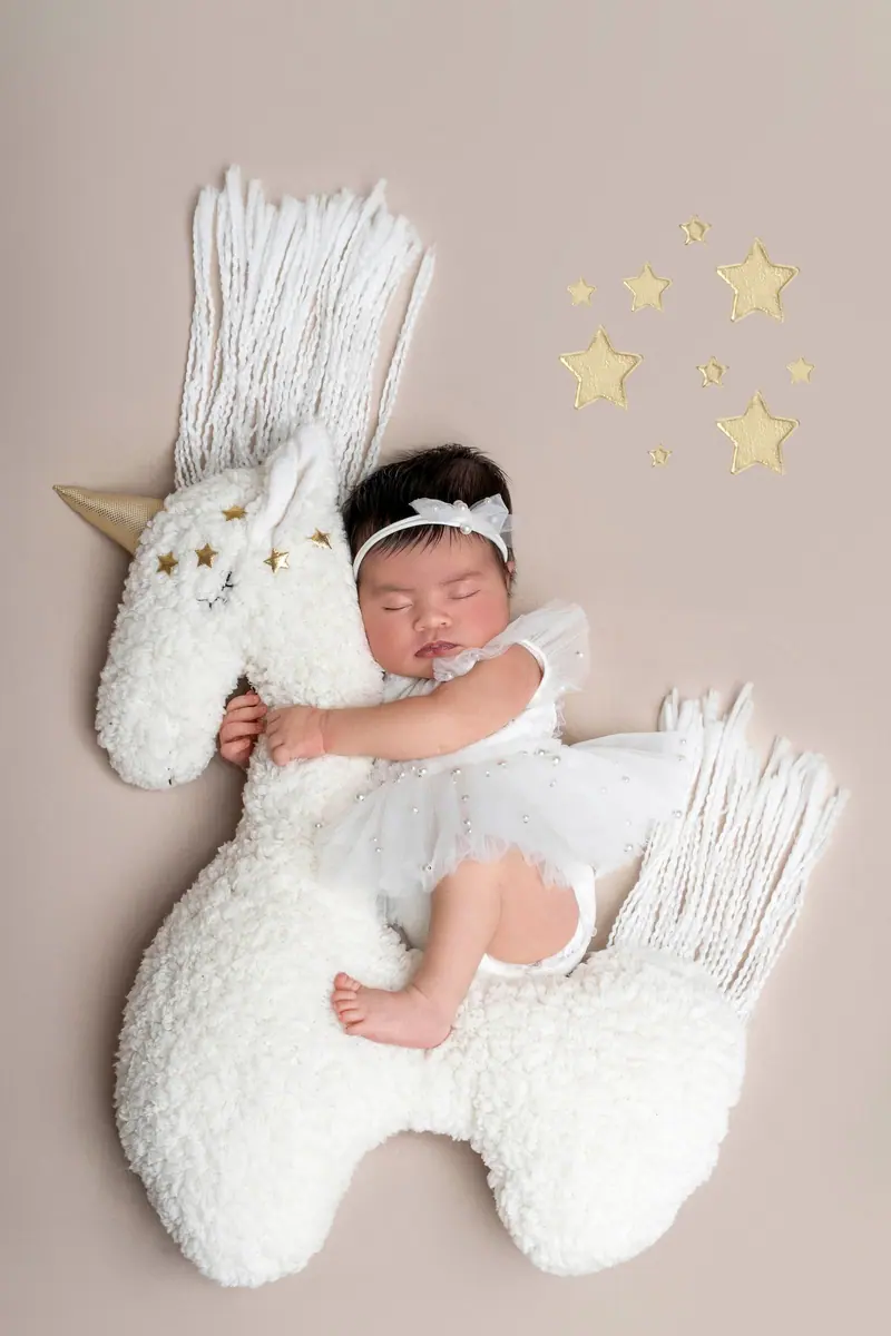 Newborn fotenie — novorodenec na plyšovom jednorožcovi