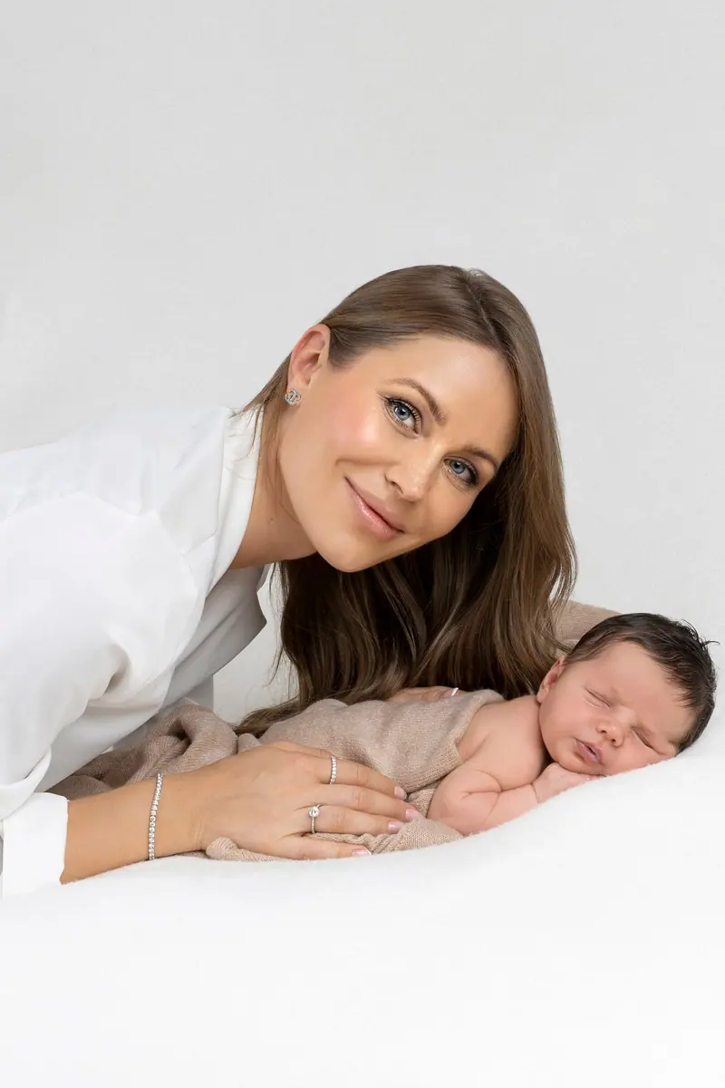 Fotenie mama a baby — mama v bielej košeli leží pri novorodencovi
