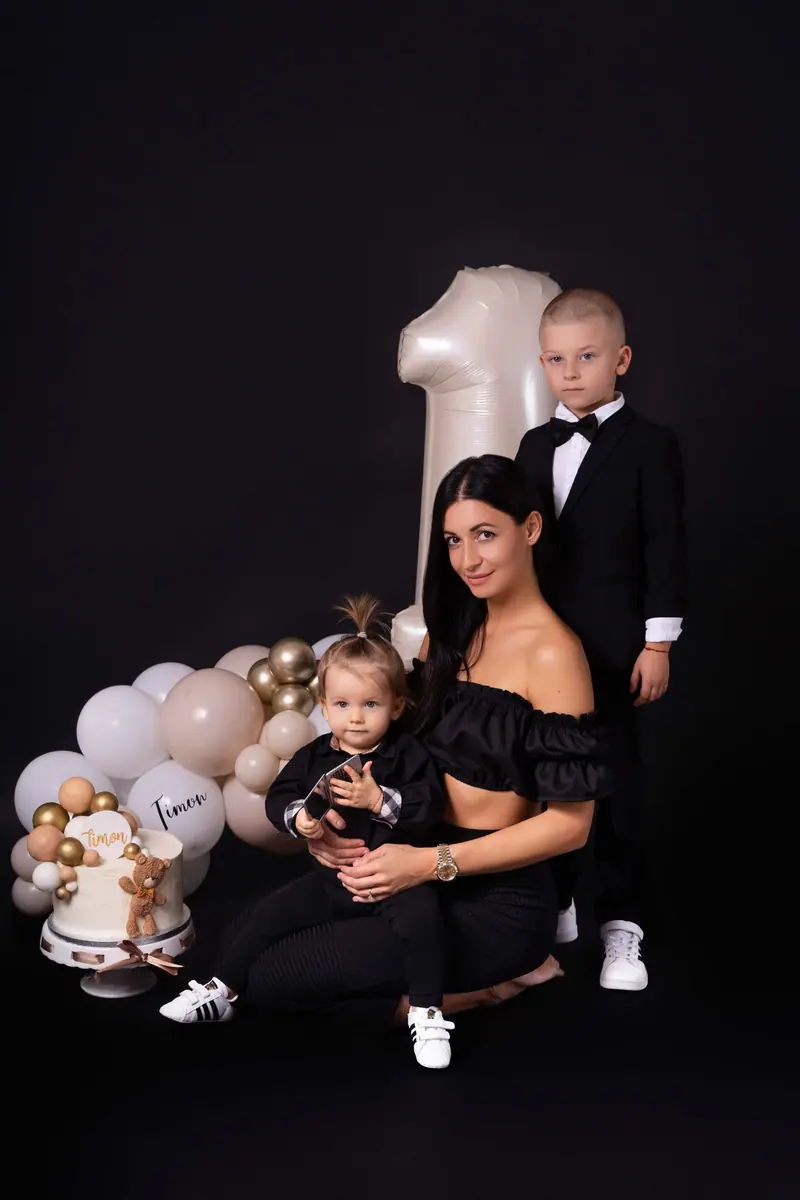 Narodeninové fotenie — mama v čiernom so synom v smokingu a dievčatkom, balón „1“