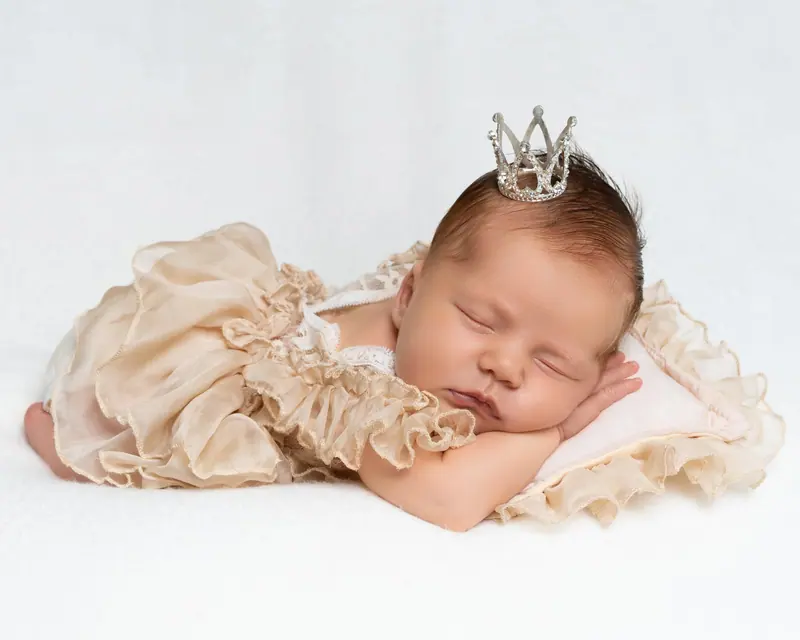 Newborn fotenie — bábätko v krémových volánoch s korunkou