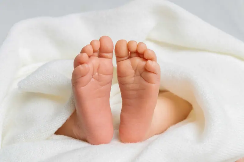 Newborn fotenie — detail chodidiel novorodenca v bielej deke