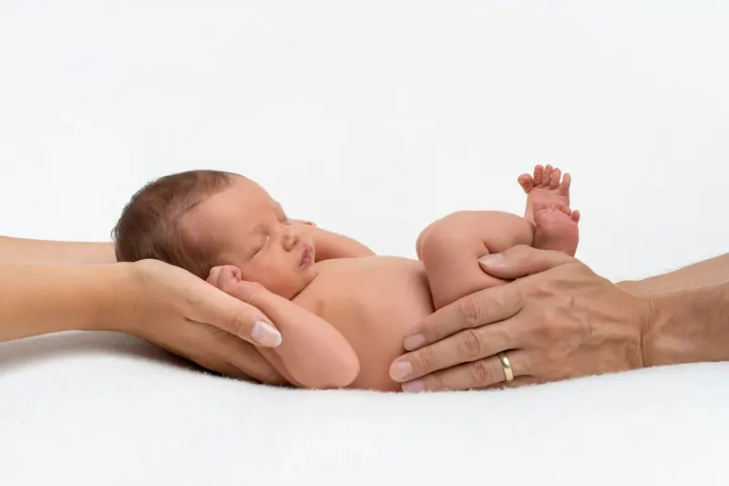 Newborn fotenie — novorodenec v dlaniach rodičov