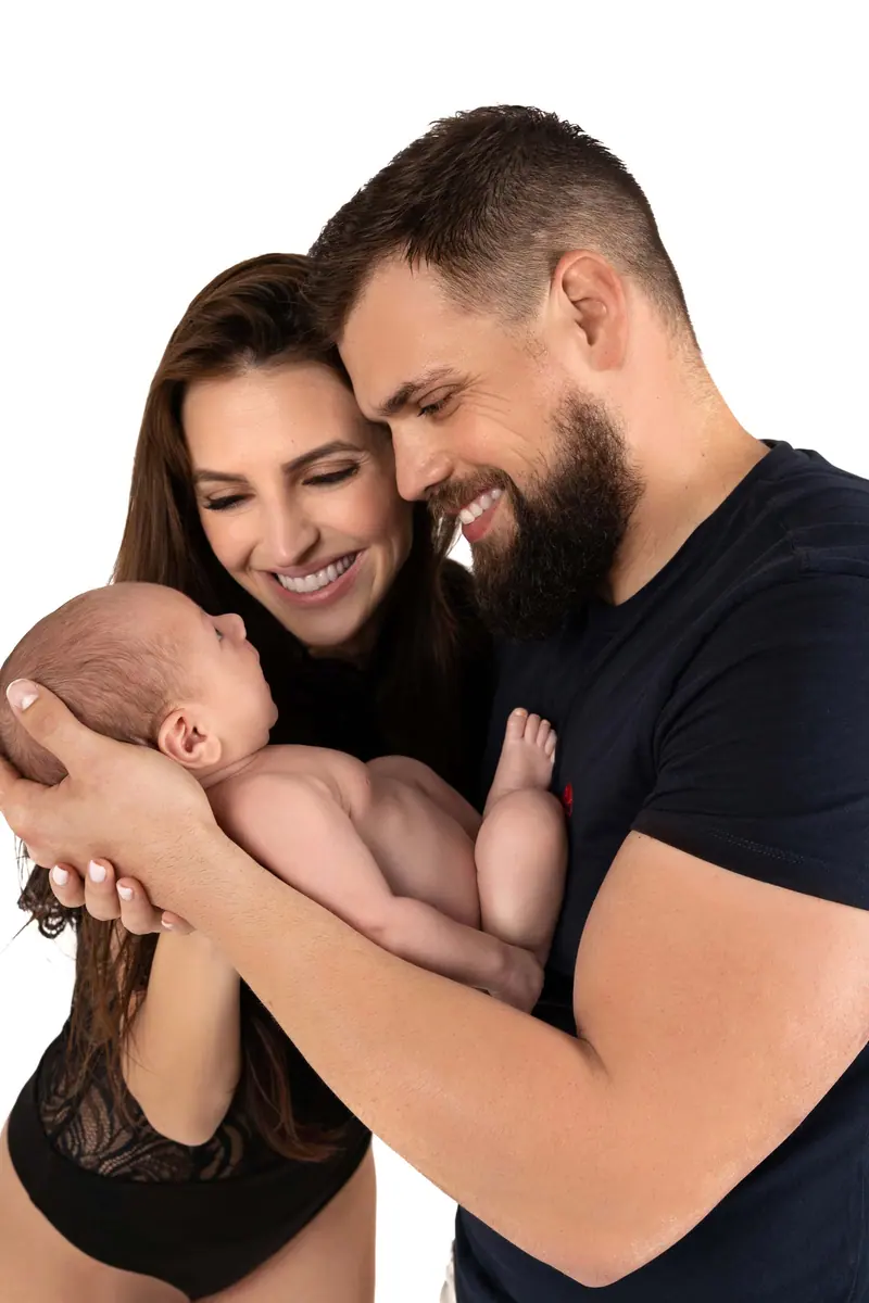 Newborn fotenie — rodičia sa usmievajú nad novorodencom, biele pozadie