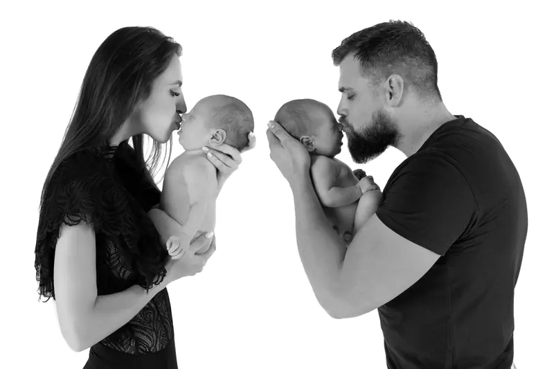 Newborn fotenie — koláž: mama a otec bozkávajú novorodenca — čiernobiela